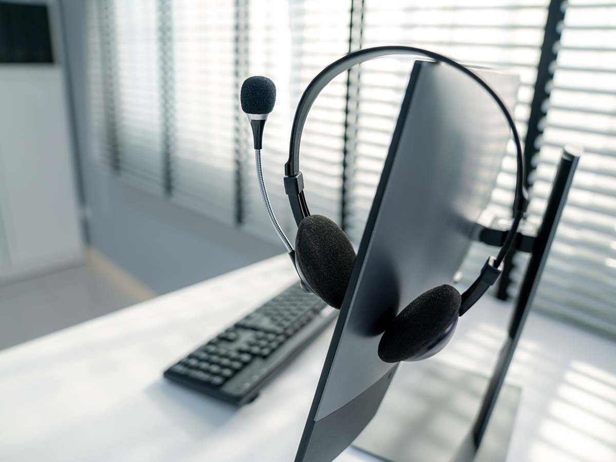 Modernes IT-Support-Arbeitsplatz-Setup mit Headset und Computer-Monitor, ideal für Remote-IT-Support und Kundenservice im Homeoffice